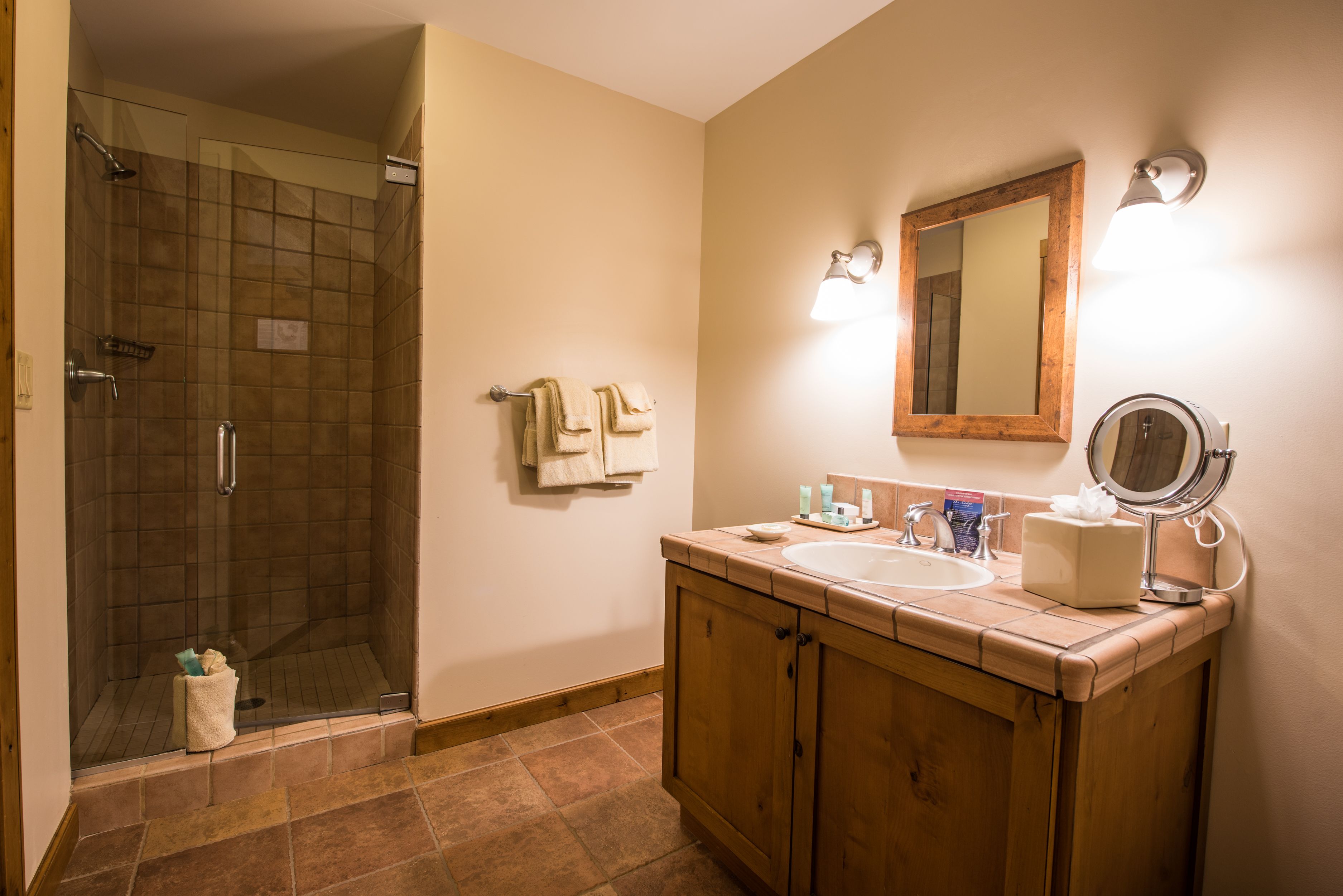 A bathroom with a shower, sink, and mirror.