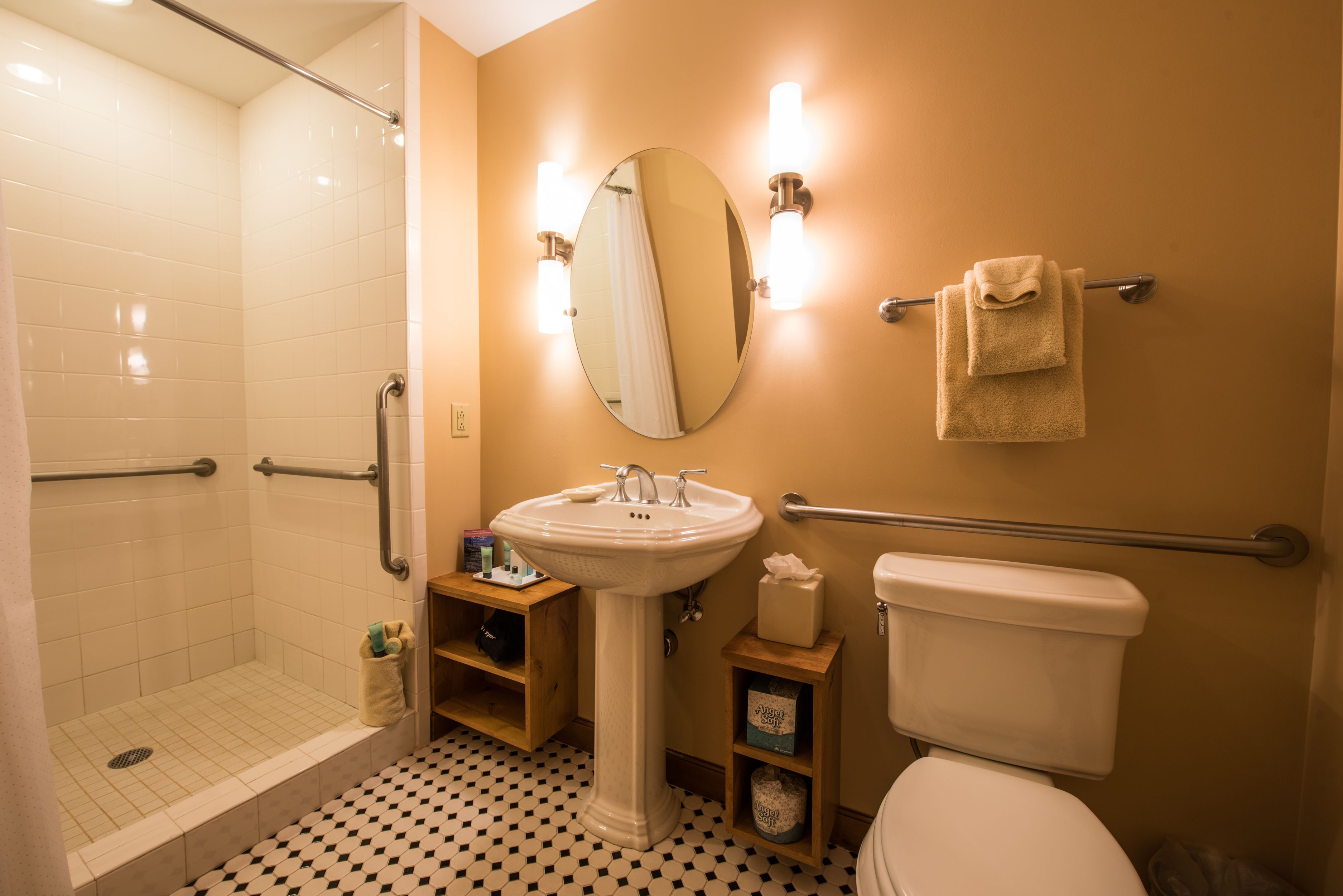 A bathroom with a white sink, a toilet, a shower with a glass door, and a mirror.
