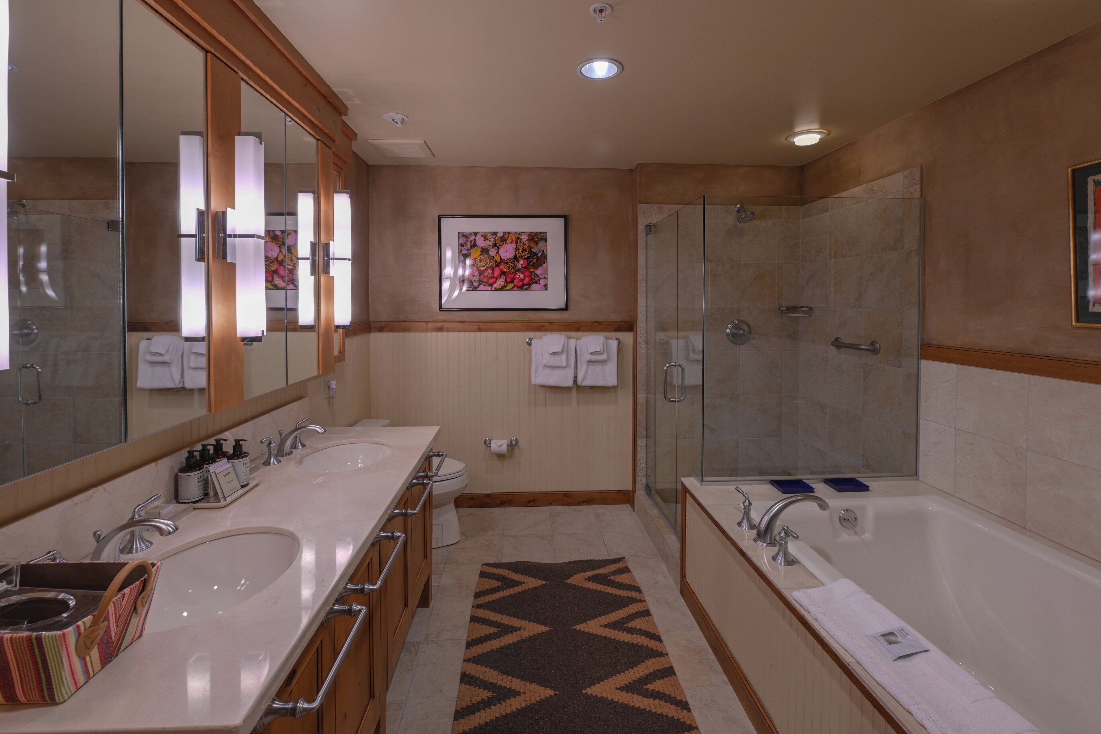 A modern bathroom with two sinks, a large bathtub, and a shower.
