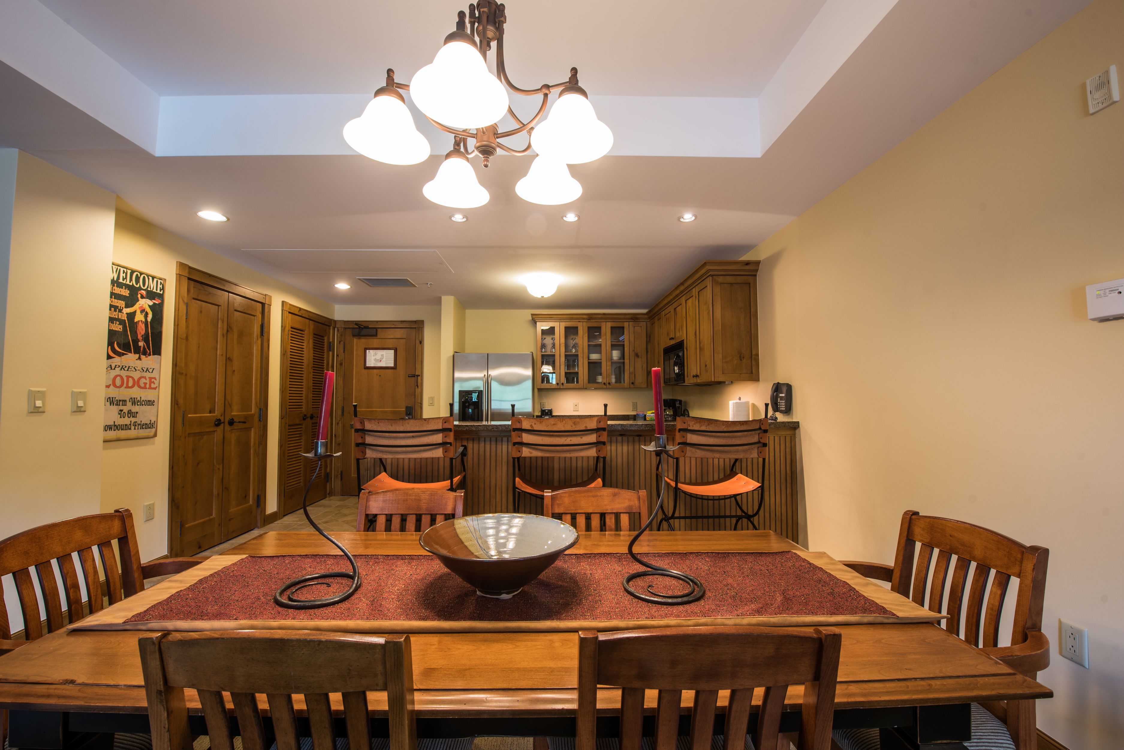 A dining area with a wooden table, chairs, and a chandelier.
