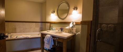 A bathroom with a bathtub, sink, mirror, and shower.