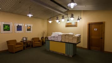 A reception area with a desk, chairs, framed pictures, and a sign indicating a fitness center.