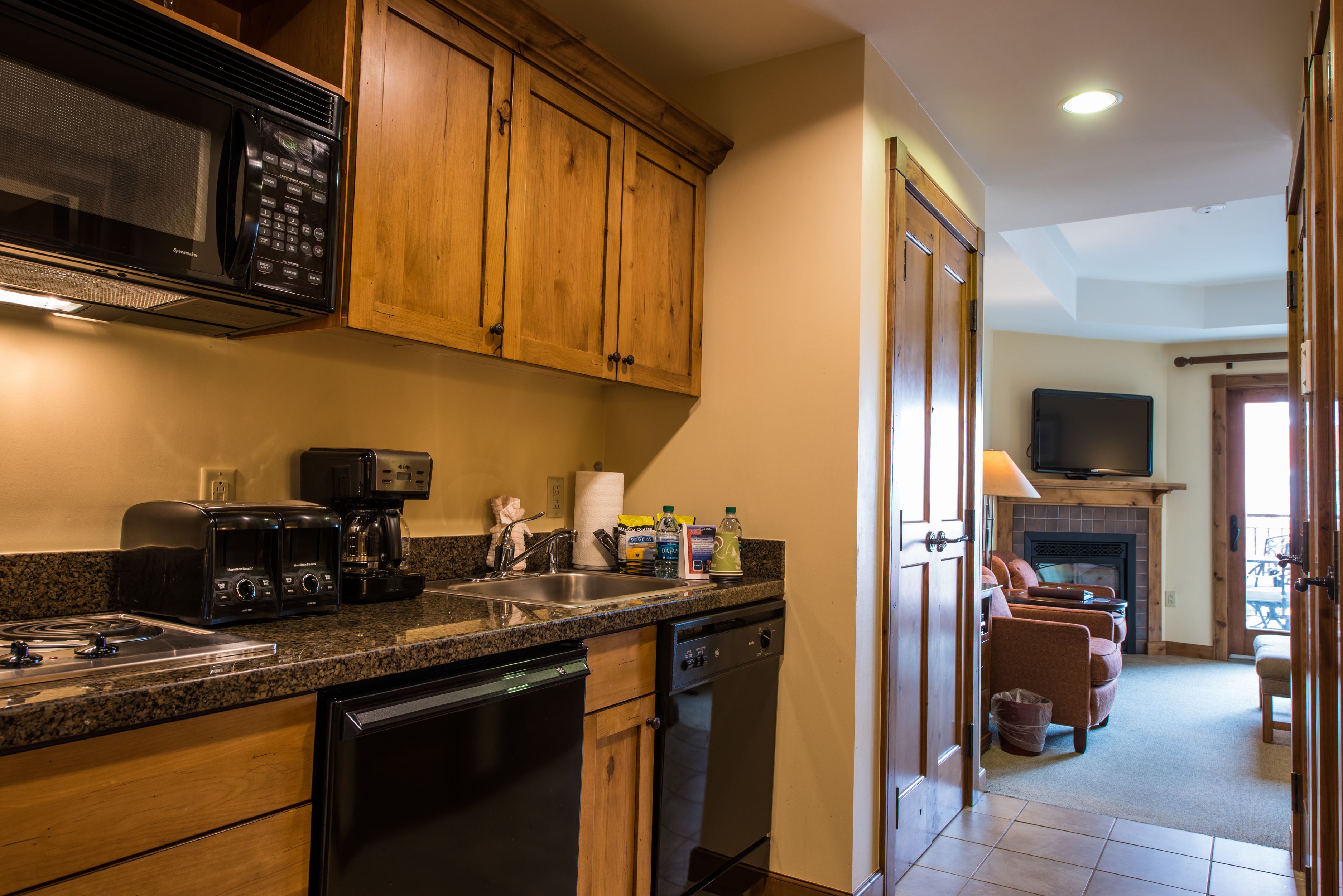 A kitchen with wooden cabinets, a microwave, a toaster, and a dishwasher.