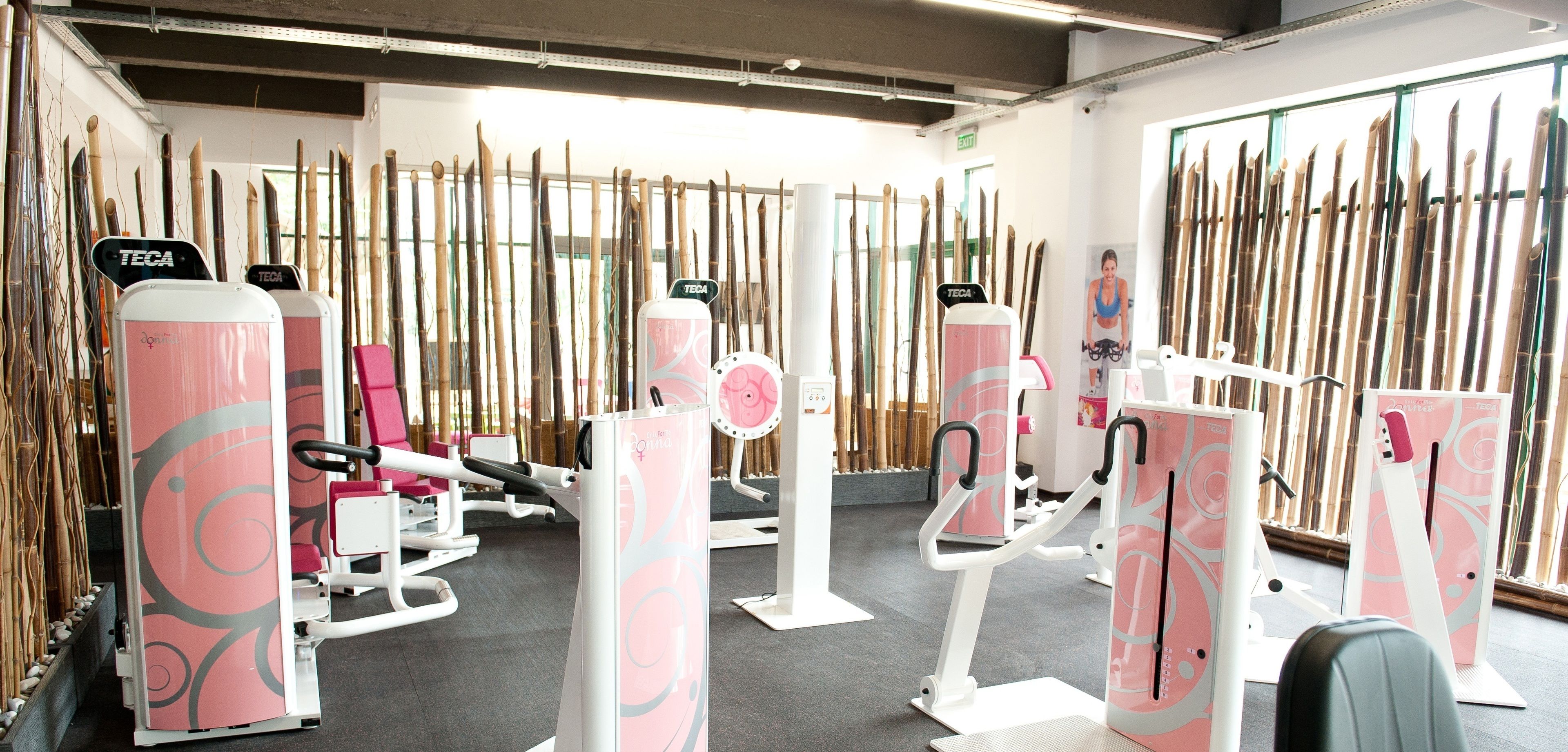 Un gimnasio con equipo de ejercicio y filas de esquíes exhibidos.