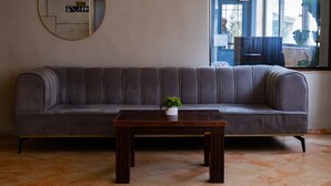 A grey sofa with a small table and a potted plant in front. - Lev Yerushalayim (Jerusalem)