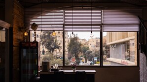 A modern interior with a large window, a vending machine, and hanging light fixtures. - Lev Yerushalayim (Jerusalem)