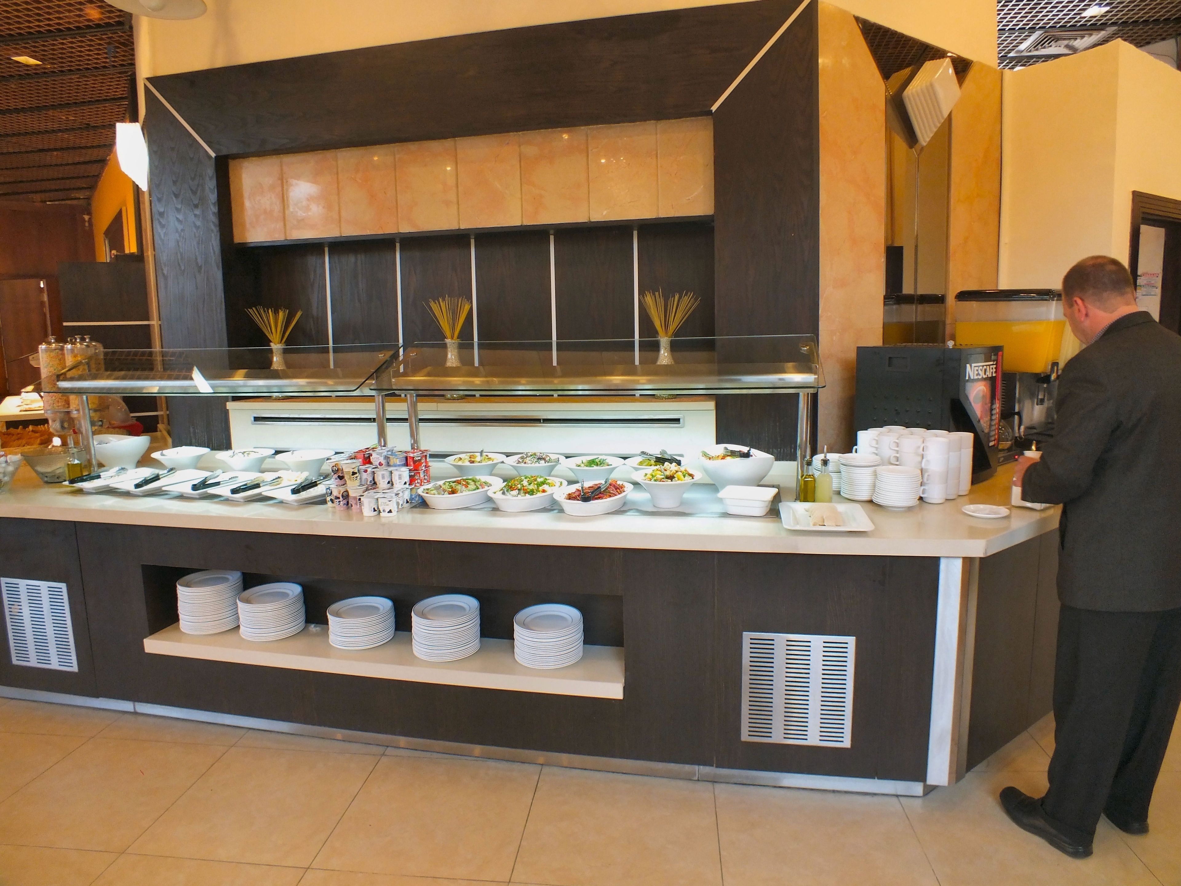 A buffet setup with various food items and a coffee station.