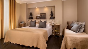 A hotel room with a large bed, two bedside tables, a nightstand, and a mirror above the bed.