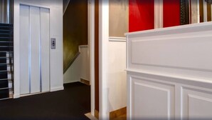 A hallway with a white door, a staircase, and a red wall. - The B Place Hotel (Rome)