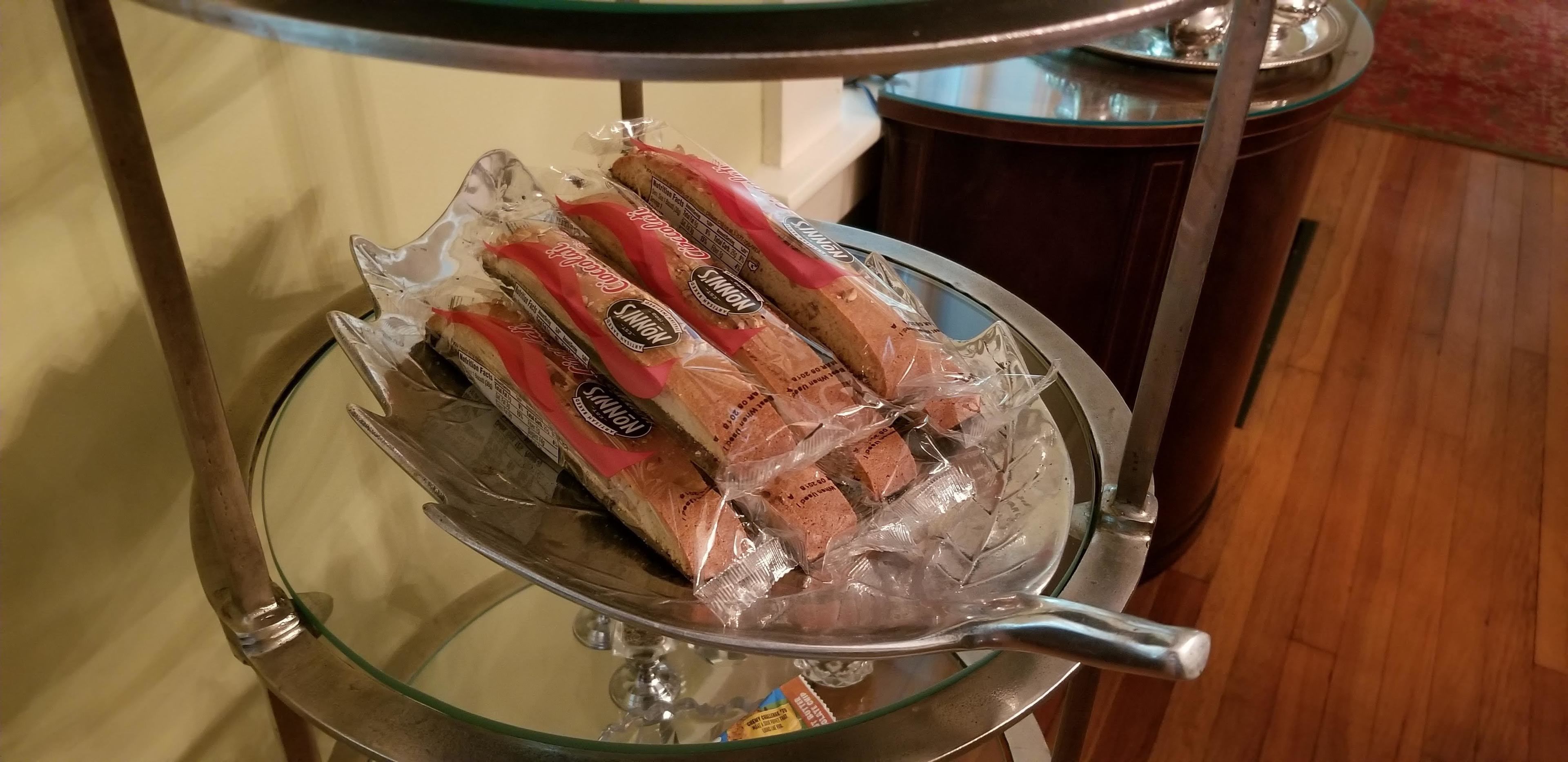 A glass display case with bread packages on a metal stand.