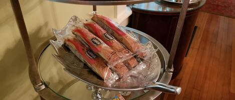 A glass display case with bread packages on a metal stand.