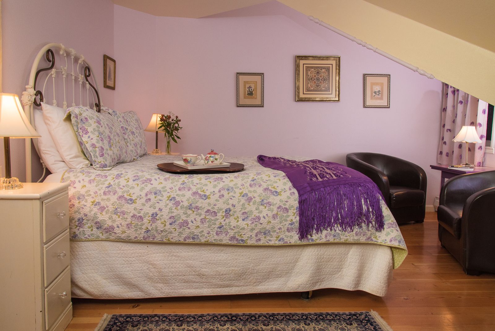 Un dormitorio con cama, mesita de noche, silla y escritorio.