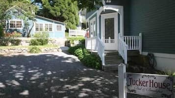 A house with a porch and a sign that reads "Tucker House."