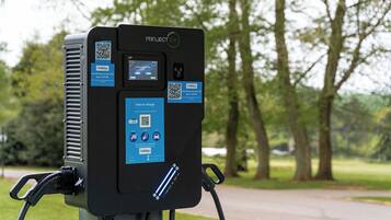 A portable electric vehicle charging station with QR codes and instructions for charging.