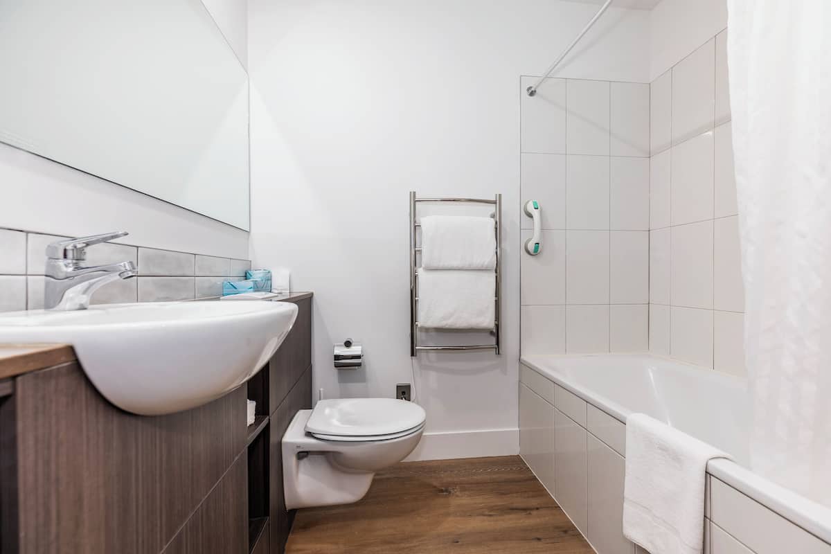 A modern bathroom with a white sink, toilet, and bathtub.