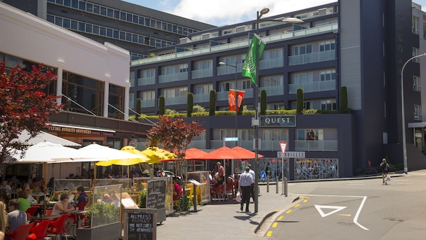 A modern building with a sign reading "QUEST" and a street-level café with outdoor seating. - Quest Newmarket (Auckland)