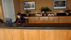 A reception area with a wooden counter, a computer, and framed pictures on the wall.