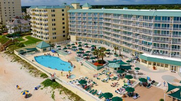 Ein Hotel mit großem Pool, mehreren Balkonen und einem Strandbereich.