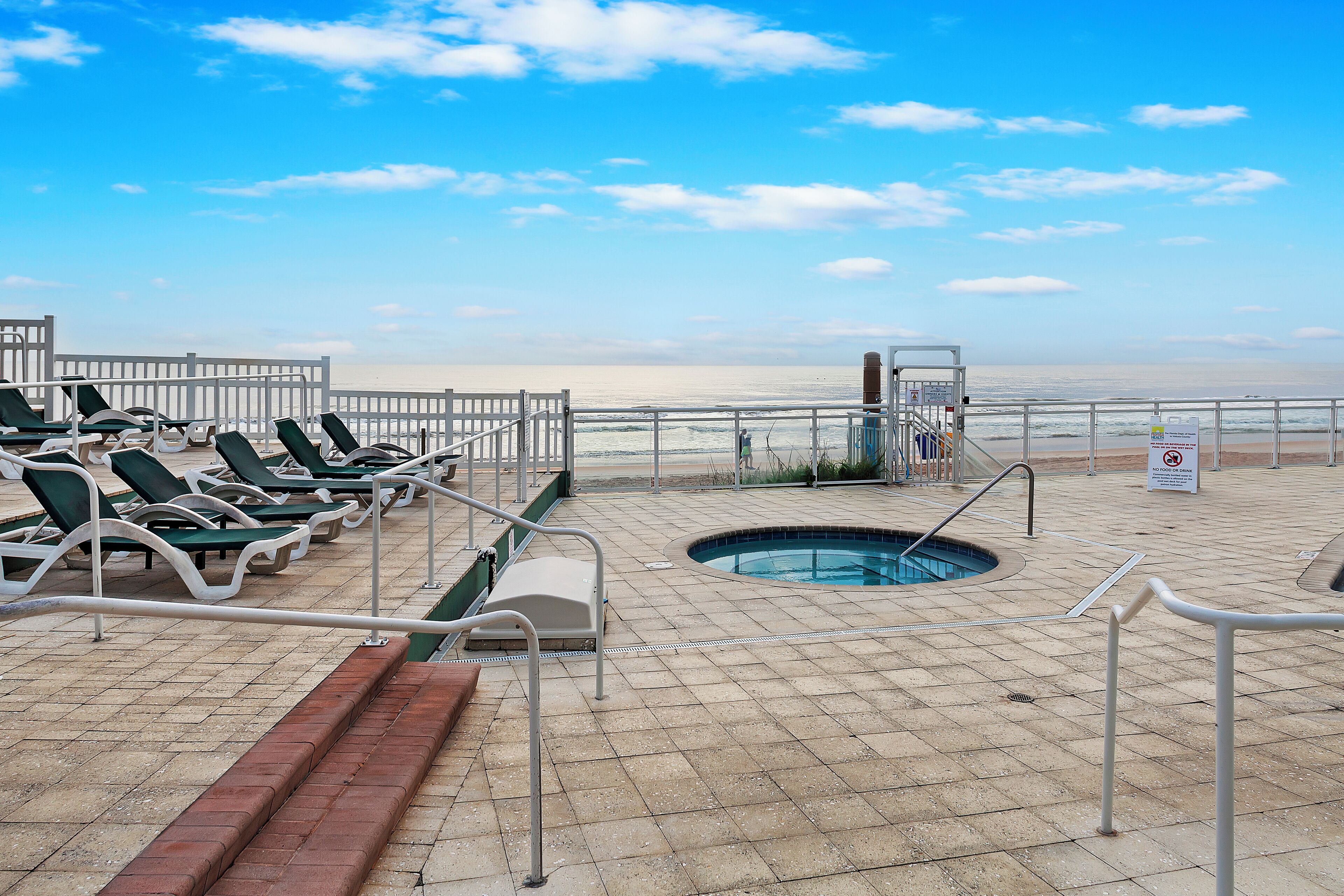 A pool area with lounge chairs and a small pool.