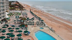 Un resort con piscina, playa y zonas de estar al aire libre.