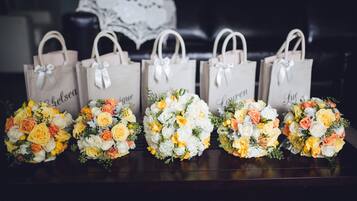 Five wedding gift bags with bouquets on a table.
