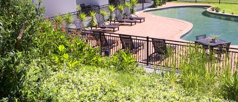 A hotel with a pool, outdoor seating, and a view of the countryside.