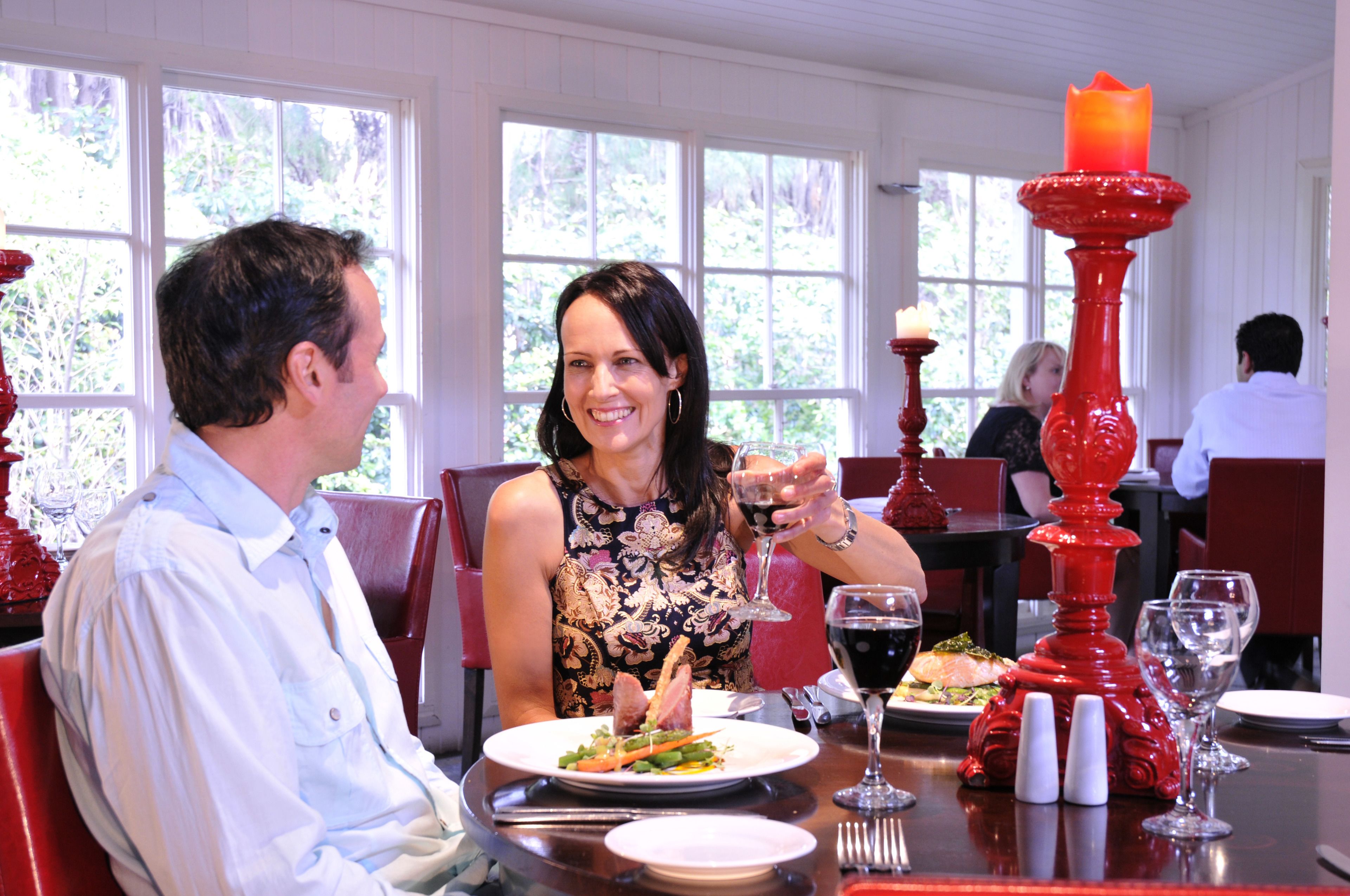 A dining area with tables, chairs, and a candle centerpiece.