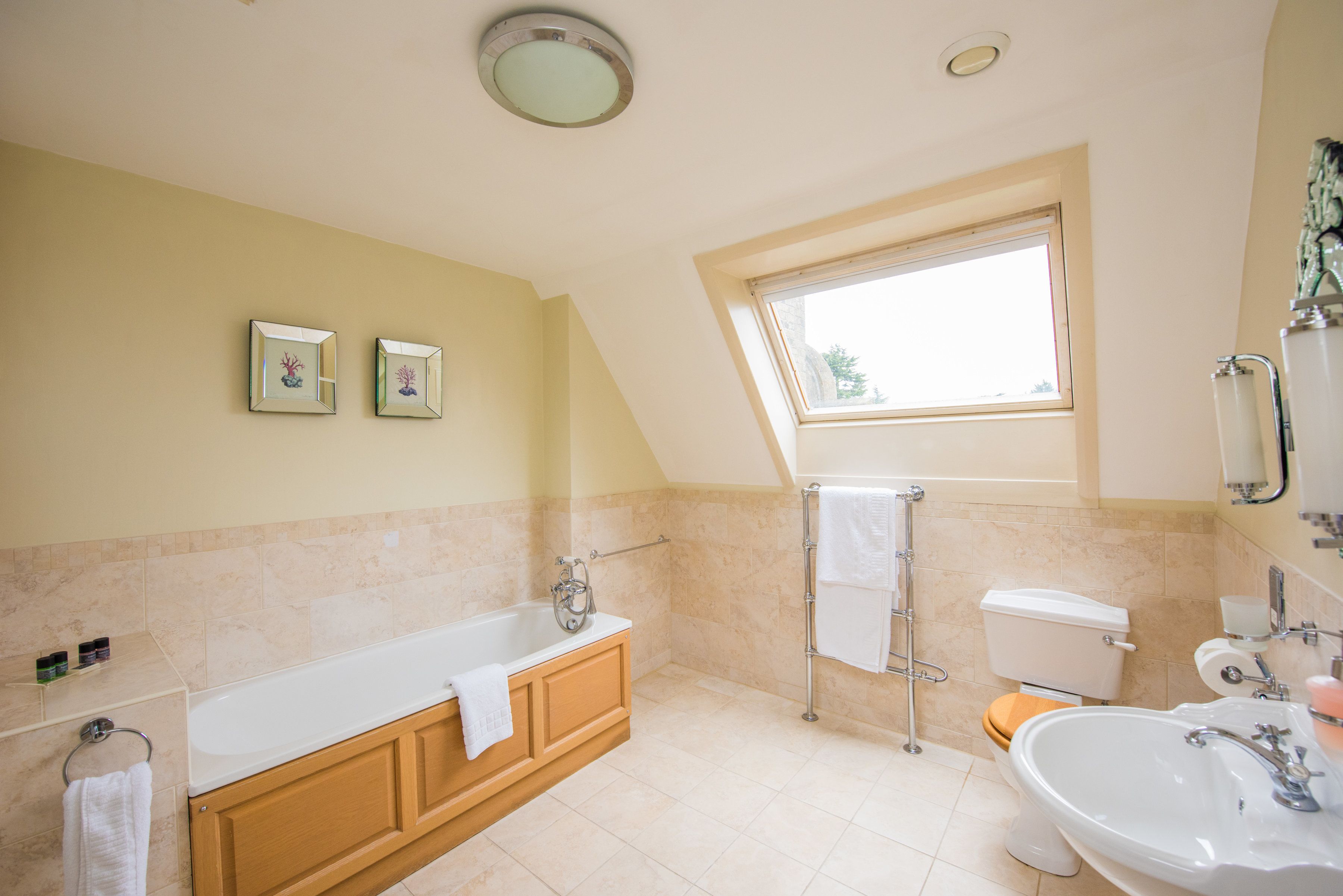 Un baño con bañera, inodoro, lavabo y ventana.