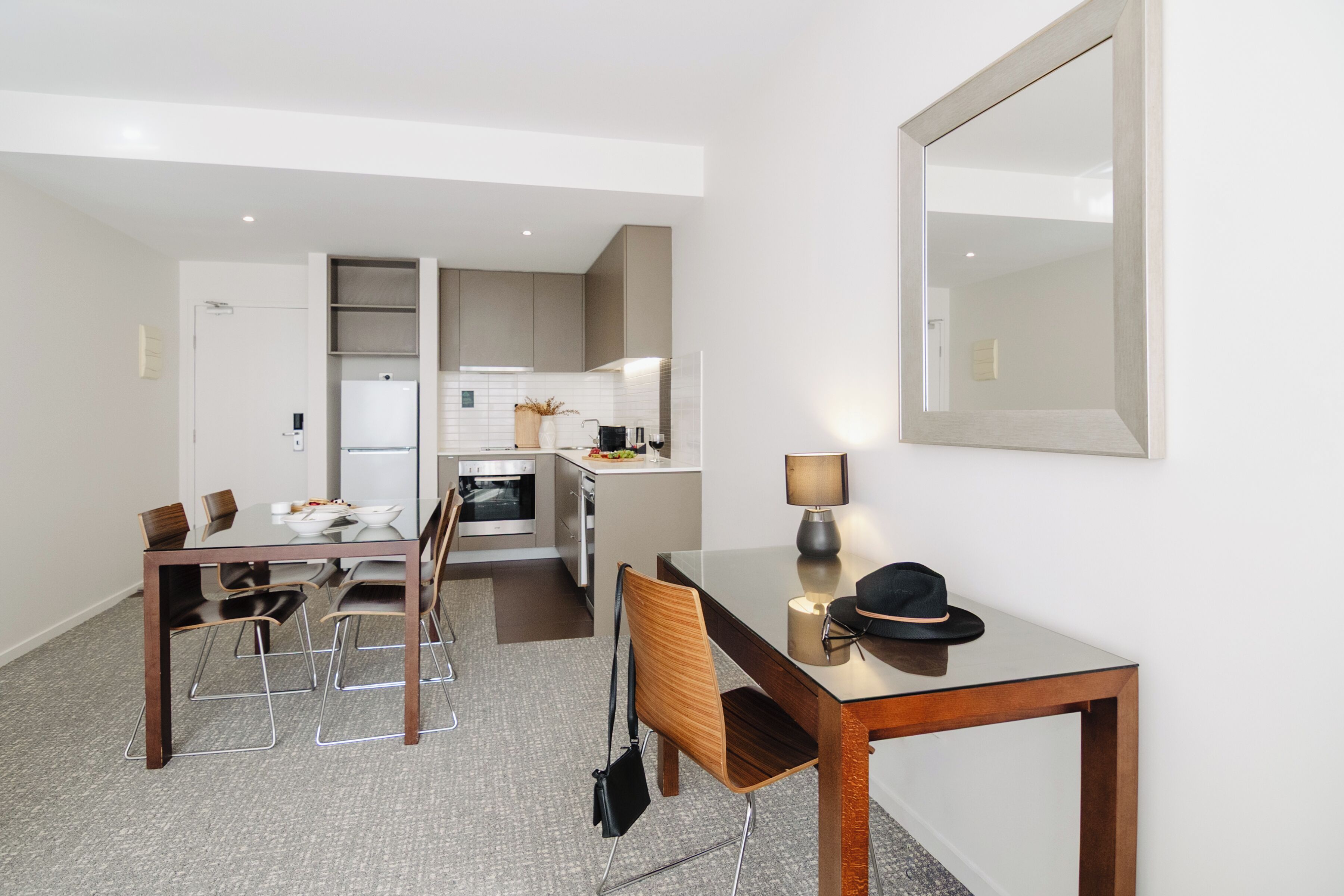 Une cuisine moderne avec un coin repas, comprenant une table, des chaises et un miroir.