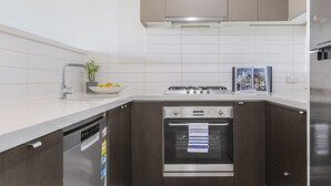 Une cuisine moderne équipée d’un lave-vaisselle, d’un four et d’appareils électroménagers en acier inoxydable.