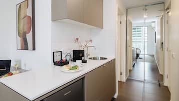 A modern kitchen with a dishwasher, a coffee machine, and a sink.
