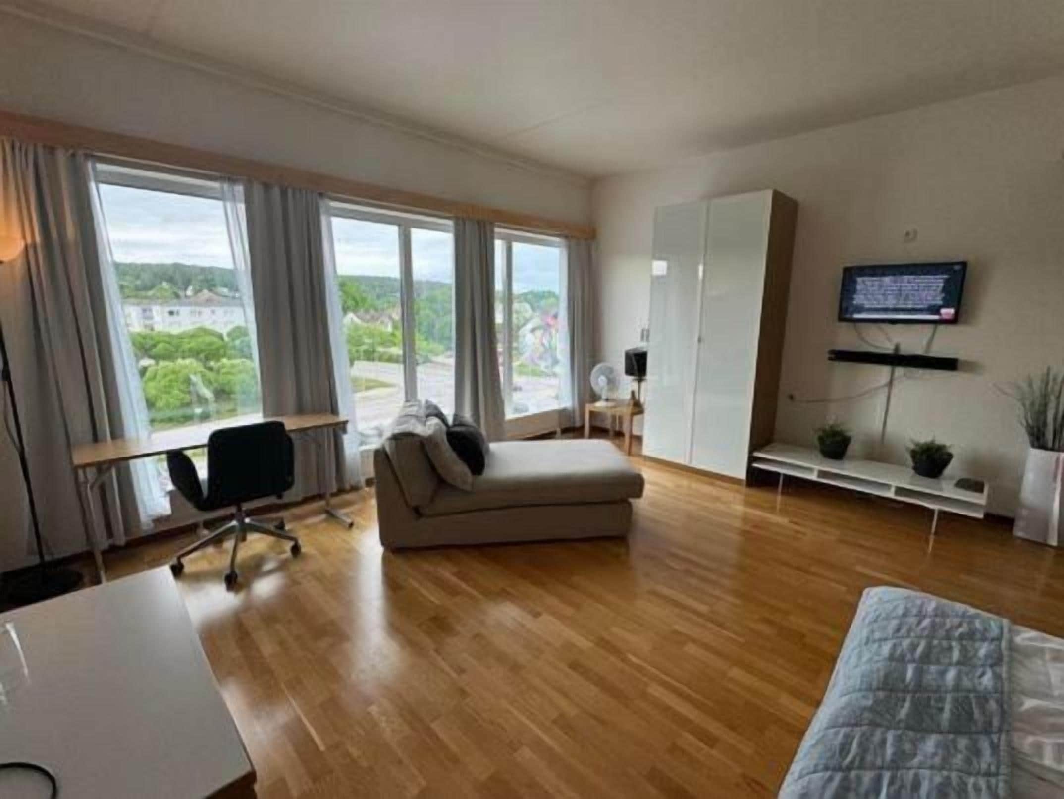 A modern living room with a sofa, a desk, and a television.