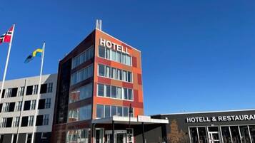 Hotel with a prominent sign, adjacent to a restaurant and dining facilities.