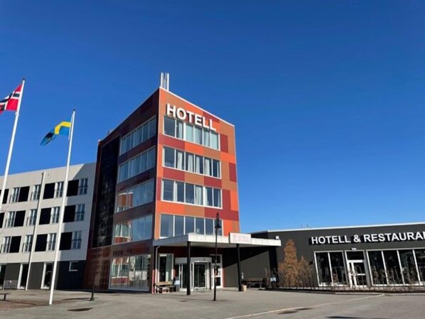 Hotel with a prominent sign, adjacent to a restaurant and dining facilities.