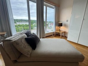 A bedroom with a bed, a nightstand, a lamp, and a view of the outdoors. - Hotell Årjäng (Årjäng)