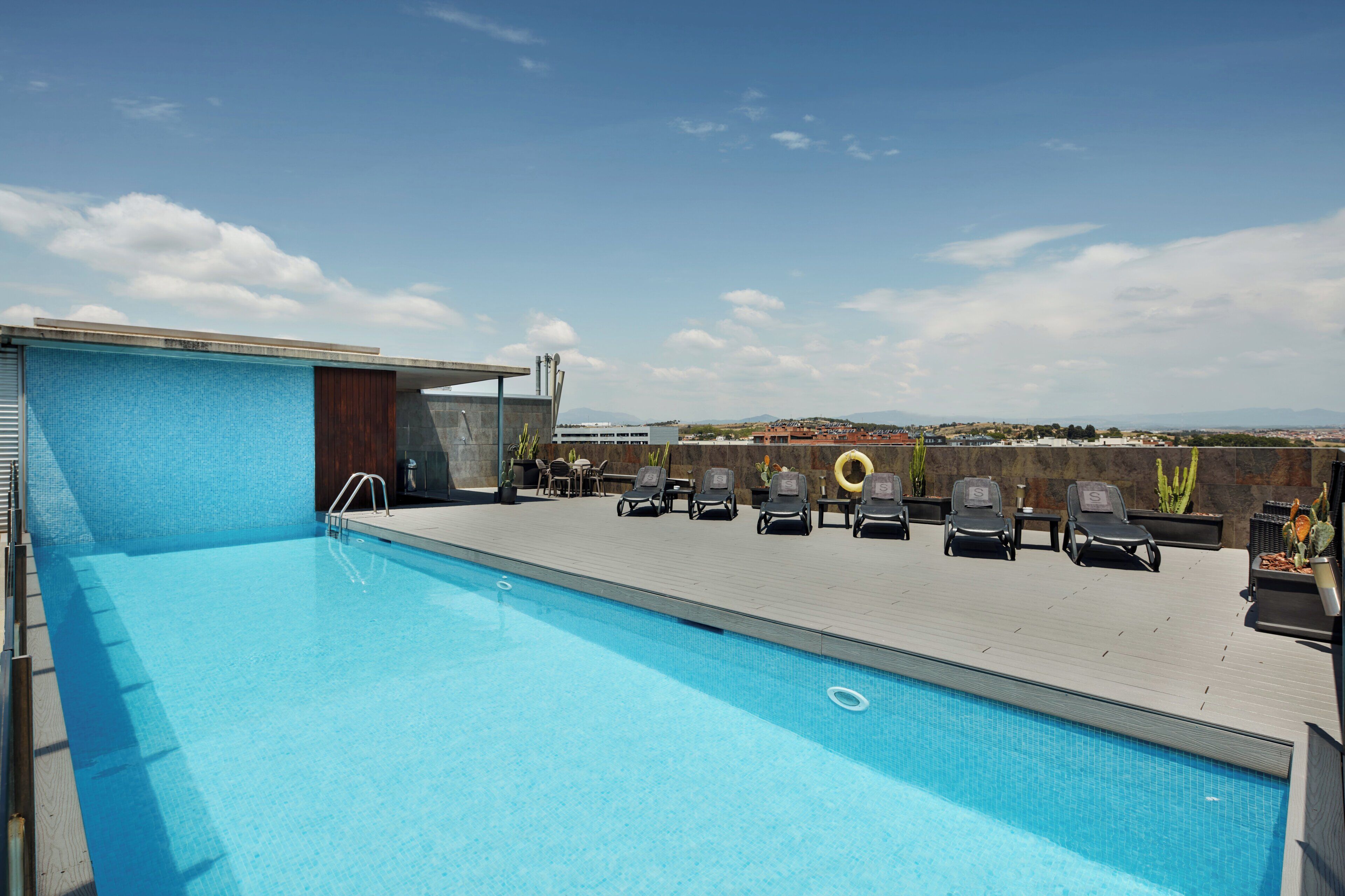Una piscina al aire libre de temporada, sillones reclinables de piscina