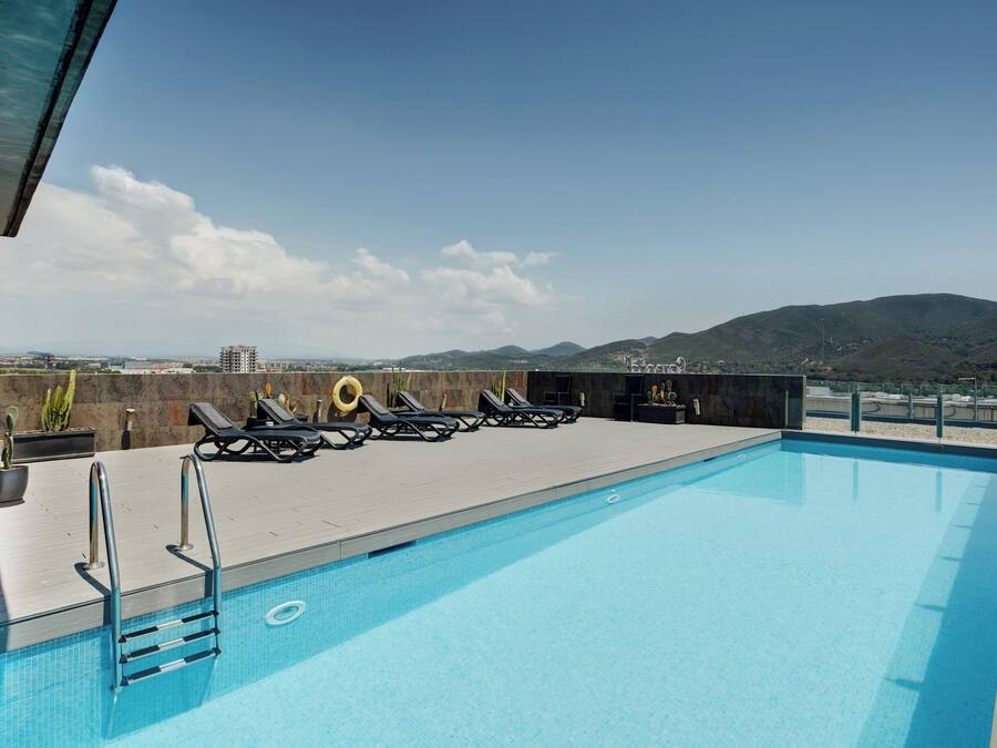 Una piscina al aire libre de temporada, tumbonas