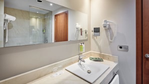 A bathroom with a large mirror, a sink, a shower, and a hairdryer. - Hotel Sercotel Ciutat de Montcada (Montcada I Reixac)