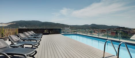 Una piscina al aire libre, tumbonas