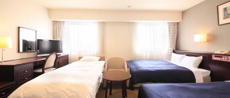 Quarto de hotel com duas camas, uma escrivaninha com televisão, uma cadeira e um abajur.