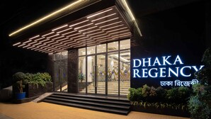A modern building with a glass facade and illuminated signage reading "DHAKA REGENCY". - Dhaka Regency Hotel & Resort (Dhaka)