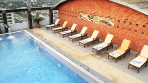 A rooftop pool with lounge chairs and a mural on the wall. - Dhaka Regency Hotel & Resort (Dhaka)