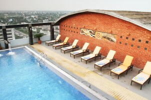Una piscina al aire libre, sillones reclinables de piscina