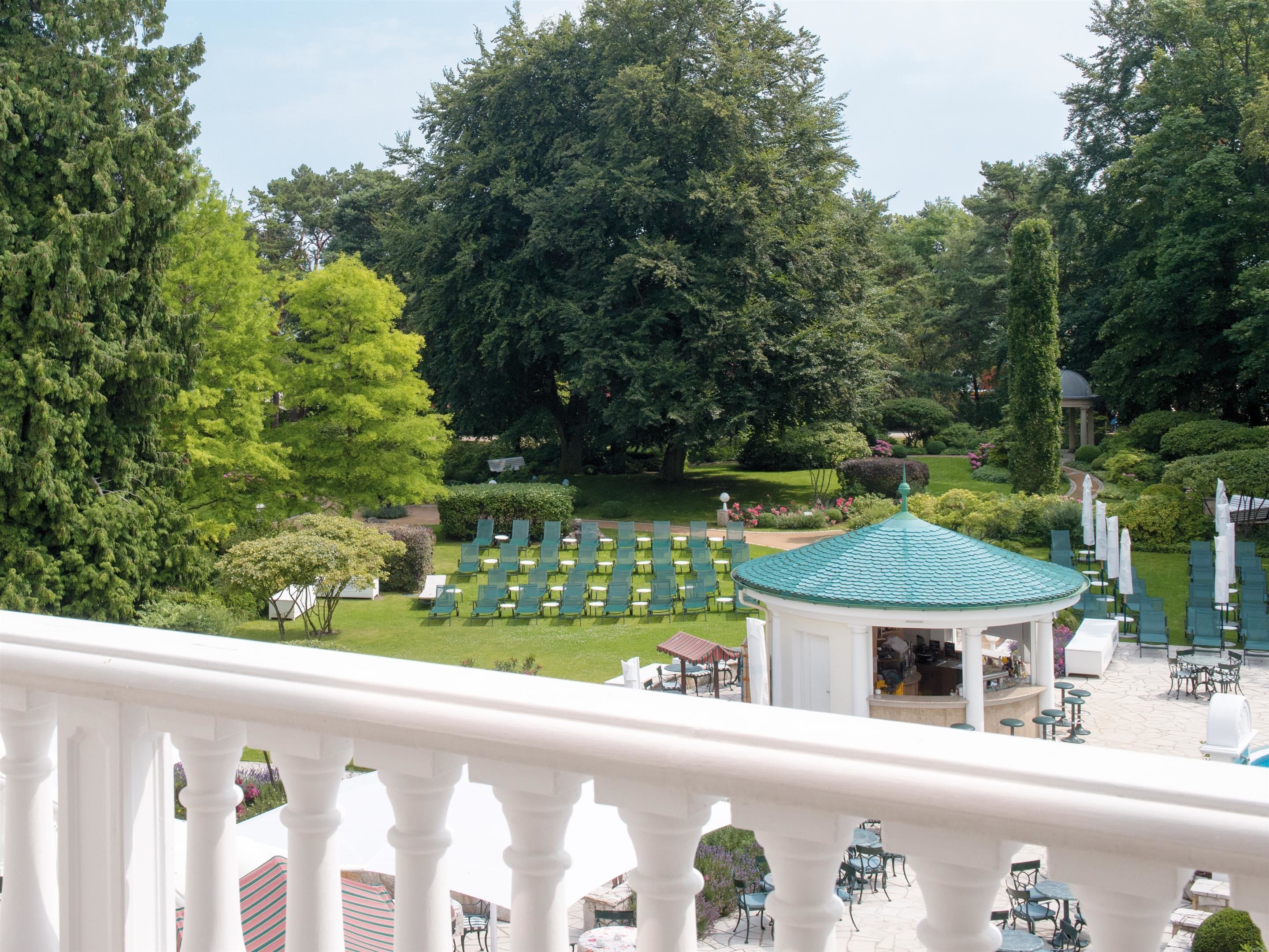 A garden with a gazebo, outdoor seating, and a lawn area.