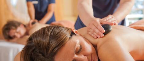 A massage therapy session in a room with wooden walls and a massage table.