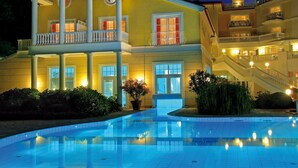 A large, two-story building with a swimming pool in front.
