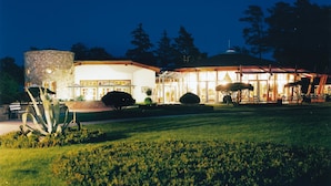A building with a stone tower, a covered patio area, and a well-maintained lawn. - Bernstein Prerow (Ostseebad Prerow)
