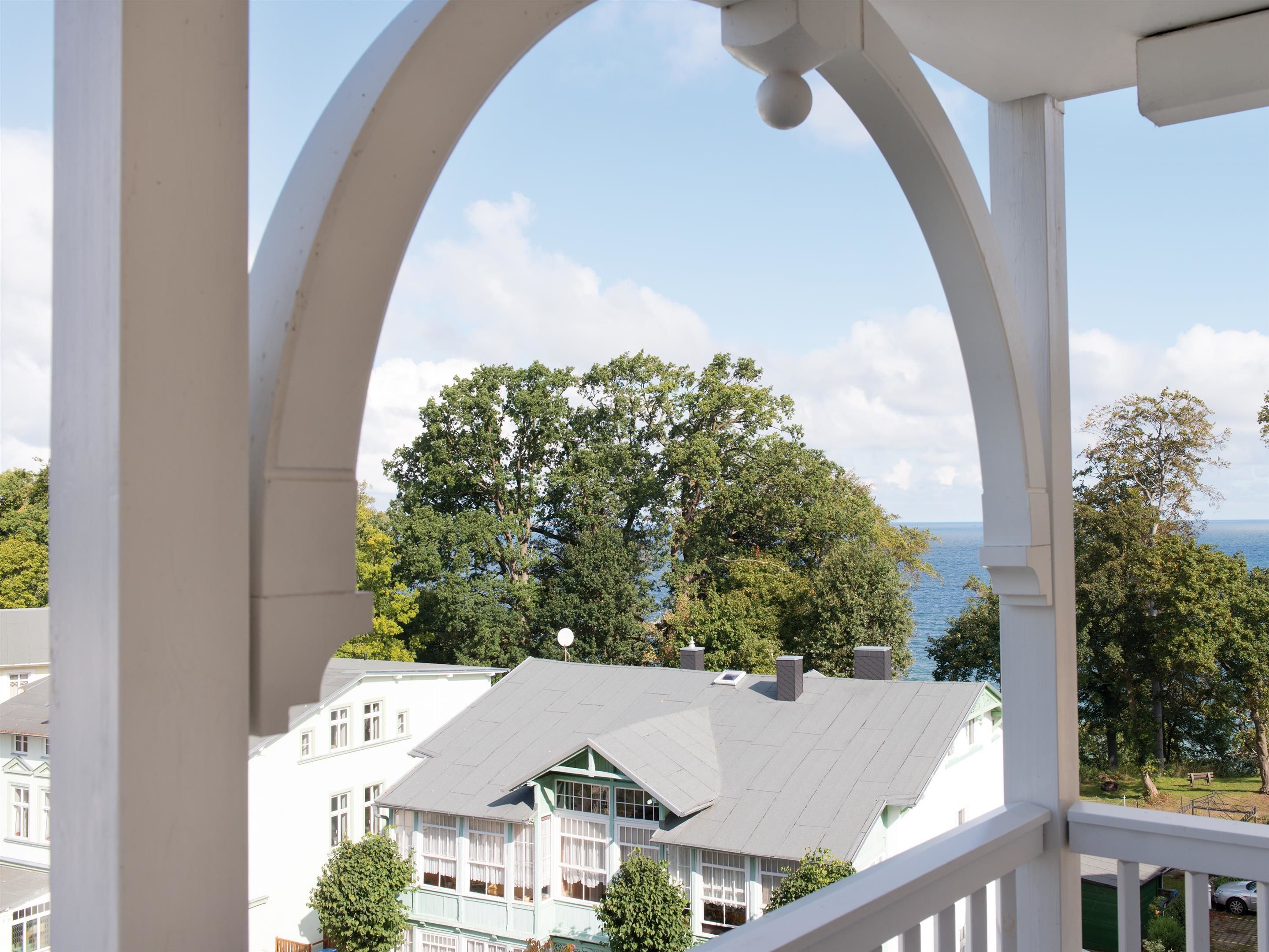 Un balcon donnant sur un immeuble et des arbres.