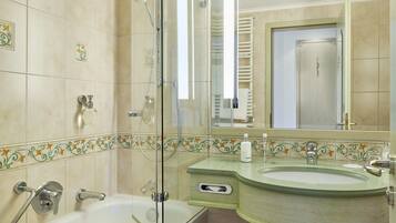 Un baño con ducha de vidrio, una bañera y un lavamanos con encimera verde.