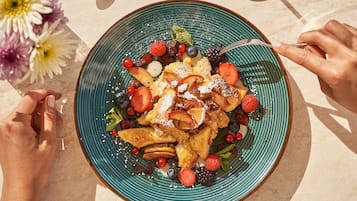 A plate of food with various fruits and a spoon.